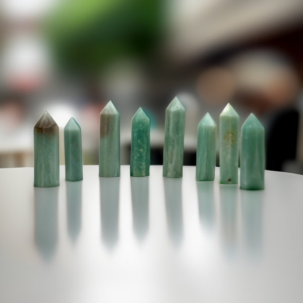 A collection of Caribbean Calcite crystal towers standing on a reflective surface with a blurred background